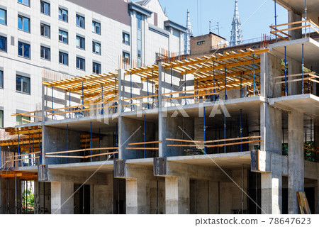 The stage of construction of a multi-storey building using a monolithic-frame method with metal supports inside the building. The stage of construction of a multi-storey building using a monolithic-frame method with metal supports inside the building. 78647623