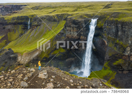Aerial view of man standing on the cliff edge enjoying Iceland highland valley and Haifoss waterfall Aerial view of man standing on the cliff edge enjoying Iceland highland valley and Haifoss waterfall 78648068