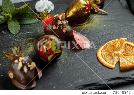Fresh chocolate covered strawberries on a gray decorative background. Concept for advertising the summer seasonal menu Fresh chocolate covered strawberries on a gray decorative background. Concept for advertising the summer seasonal menu 78648542