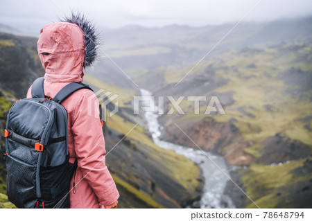 Close up of a woman with backpack enjoying icelandic highland and river fossa close to Haifoss waterfall in Iceland Close up of a woman with backpack enjoying icelandic highland and river fossa close to Haifoss waterfall in Iceland 78648794