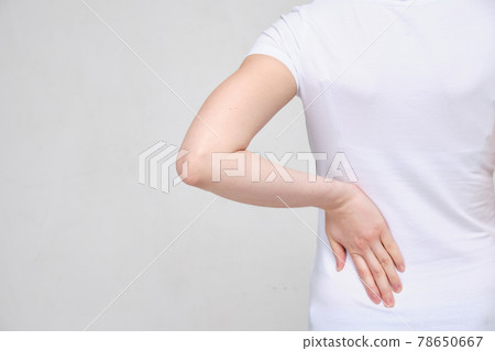 A girl in a white T-shirt suffers from pain in the side of the lower back. Sciatica concept. 78650667