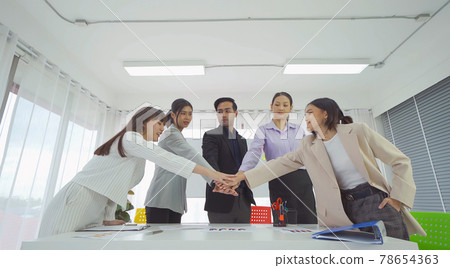 Group of Asian successful business people stacking hands together to cheer up team together in meeting, communicate, discuss, and working with colleagues in office. People lifestyle.Corporate teamwork Group of Asian successful business people stacking hands together to cheer up team together in meeting, communicate, discuss, and working with colleagues in office. People lifestyle.Corporate teamwork 78654363
