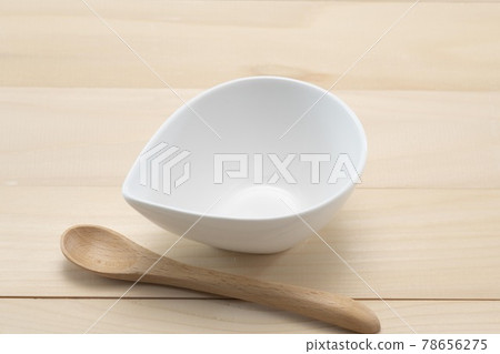 White plate and spoon on a wooden table 78656275
