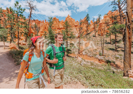 Hiking couple hikers walking smiling happy in summer mountain nature. Interracial couple Asian woman and Caucasian man in Bryce Canyon National Park landscape, Utah, United States 78656282