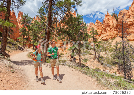 People hiking - couple hikers in Bryce Canyon walking on trail happy with backpacks. Multiracial young Asian woman and Caucasian man in Bryce Canyon National Park landscape, Utah, United States People hiking - couple hikers in Bryce Canyon walking on trail happy with backpacks. Multiracial young Asian woman and Caucasian man in Bryce Canyon National Park landscape, Utah, United States 78656283