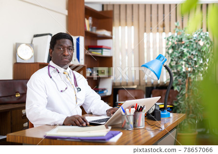 African american physician working with laptop in office African american physician working with laptop in office 78657066
