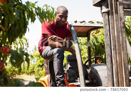 Afro male driver working on forklift 78657093