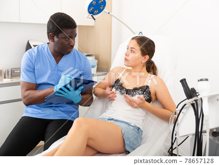 Confident male doctor consult female patient on breast augmentation 78657128