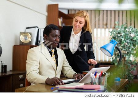 Businessman and businesswoman working together at company office 78657132