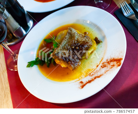 Braised pork meat in sauce with baked potato 78657457