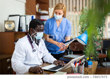 Male doctor and female in protective mask nurse having productive day Male doctor and female in protective mask nurse having productive day 78657475
