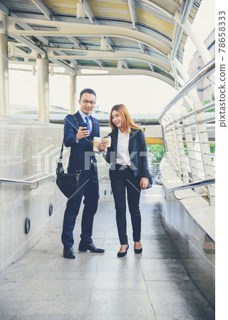 Businessman Businesswoman drinking coffee in town using smartphone outside office modern city. Hands holding take away coffee cup and smart phone talking together Business partner with cup of coffee 78658333
