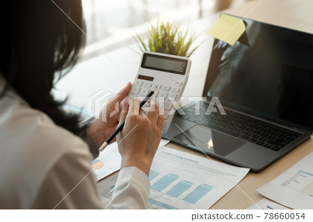 businesswoman working on desk office with using a calculator to calculate the numbers, finance accounting concept. 78660054