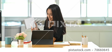 Young Asian woman video call conference online remote meeting with business coworker at home. Young Asian woman video call conference online remote meeting with business coworker at home. 78660645
