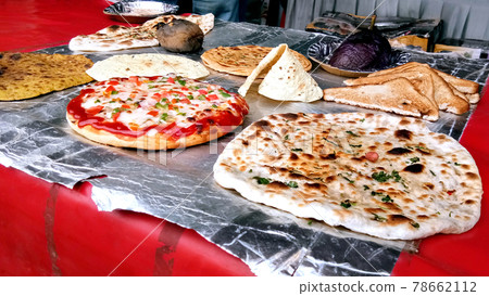 Variety of cooked chapati, prantha, pizza and other food Variety of cooked chapati, prantha, pizza and other food 78662112