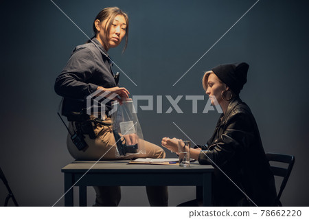 Caught blonde criminal investigator shows evidence in the form of a package with weapons Caught blonde criminal investigator shows evidence in the form of a package with weapons 78662220