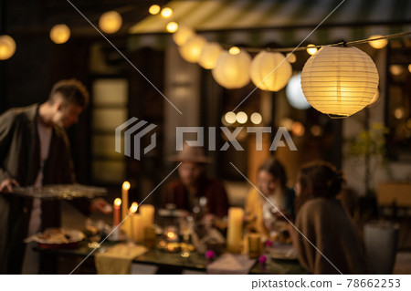 Friends dining at the backyard in the evening 78662253