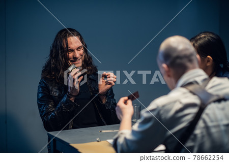 Interrogation of a homicidal maniac in the interrogation room. A police detective sits at a table with a suspect. Interrogation of a homicidal maniac in the interrogation room. A police detective sits at a table with a suspect. 78662254