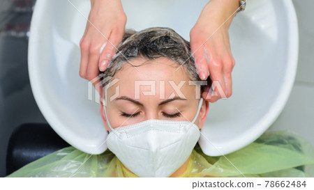 Washing the head in the barbershop, hair care, the hairdresser washes the client's head. 78662484