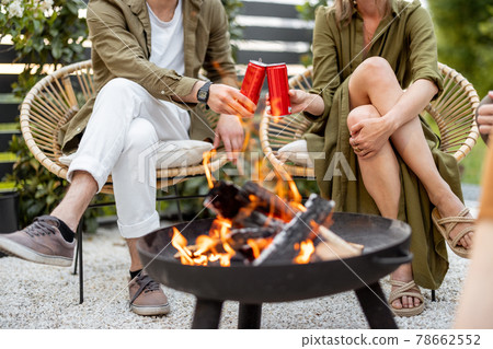 Friends by a fireplace outdoors Friends by a fireplace outdoors 78662552