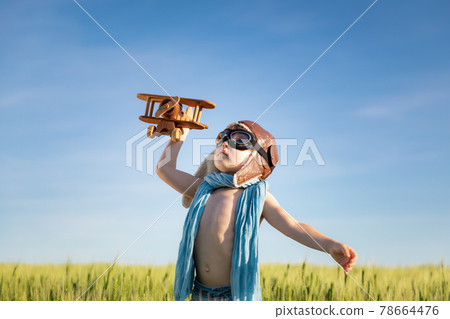 Happy child with airplane playing outdoor in summer 78664476