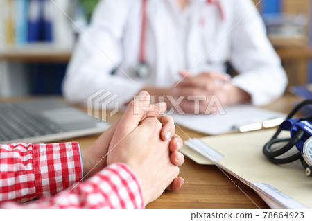 Woman sitting at table at doctor appointment in clinic closeup Woman sitting at table at doctor appointment in clinic closeup 78664923
