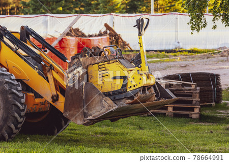 Excavator with raised up front bucket and vibration plate compactor Excavator with raised up front bucket and vibration plate compactor 78664991