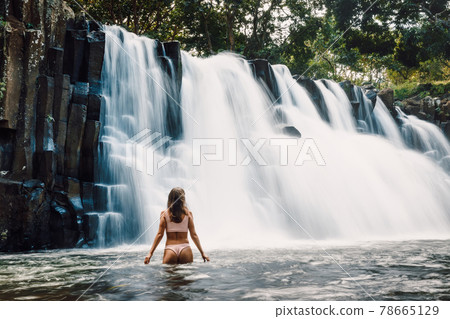 Rochester Falls waterfall and woman in bikini. Amazing cascade waterfall in Mauritius 78665129