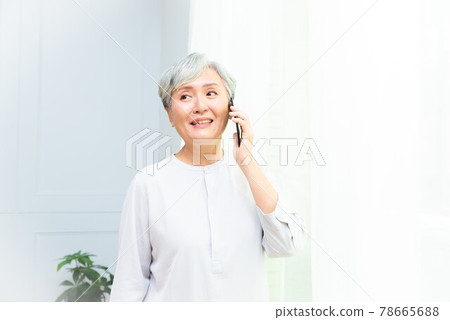 An elderly woman with silver hair talks on her mobile phone and enjoys a leisurely life An elderly woman with silver hair talks on her mobile phone and enjoys a leisurely life 78665688