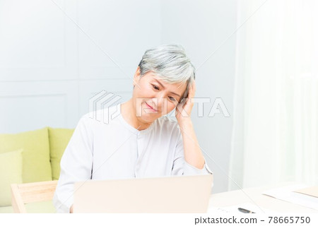 Elderly professional woman working from home during covid-19 pandemic 78665750