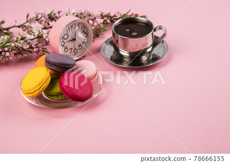 A cup of morning coffee with macaroons cookies on a pink paper background. Copy space A cup of morning coffee with macaroons cookies on a pink paper background. Copy space 78666155