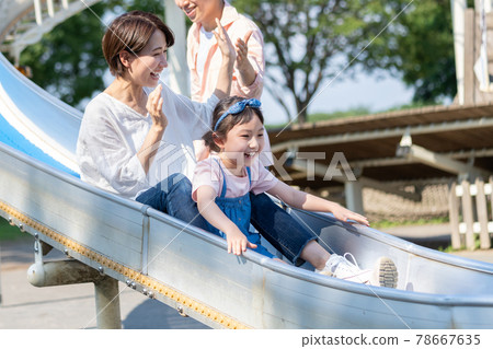 父母和孩子在公園的幻燈片上玩 78667635