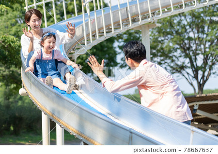 父母和孩子在公園的幻燈片上玩 78667637