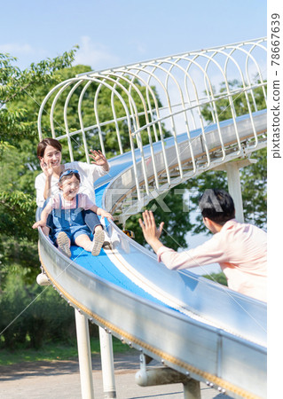 父母和孩子在公園的幻燈片上玩 78667639