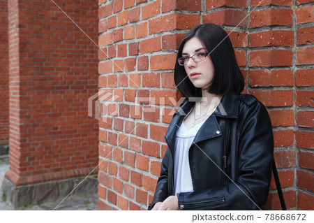 young girl stands near the wall of a gothic church young girl stands near the wall of a gothic church 78668672