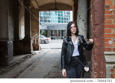 young girl stands in old arch on city street 78668781