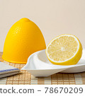 Half a lemon in a lemon plastic bowl on bamboo napkin 78670209
