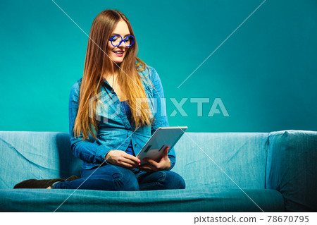 woman with tablet sitting on couch blue color woman with tablet sitting on couch blue color 78670795