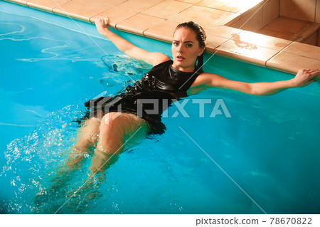 Sexy seductive woman relaxing in water at poolside Sexy seductive woman relaxing in water at poolside 78670822