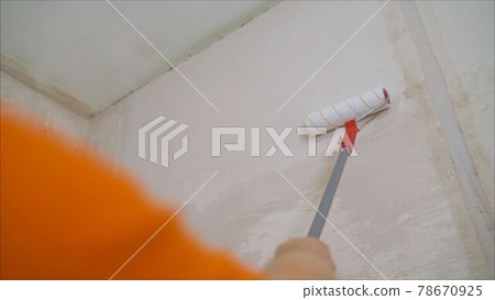 Wall paint roller. Roller Brush Painting, Worker painting on roller brush for protection Wall paint roller. Roller Brush Painting, Worker painting on roller brush for protection 78670925