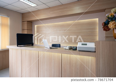 Modern wooden reception counter with monitor, laptop and electronic device in hospital 78671704