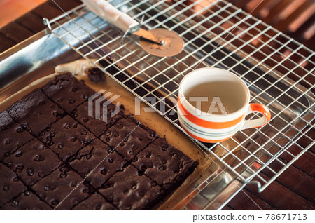 Chocolate brownie with chocolate chip and cup on grille Chocolate brownie with chocolate chip and cup on grille 78671713