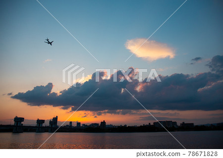 一架飛機在夕陽染紅的天空中飛翔 一架飛機在夕陽染紅的天空中飛翔 78671828