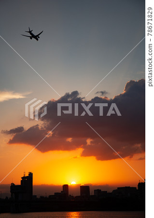 一架飛機在夕陽染紅的天空中飛翔 一架飛機在夕陽染紅的天空中飛翔 78671829