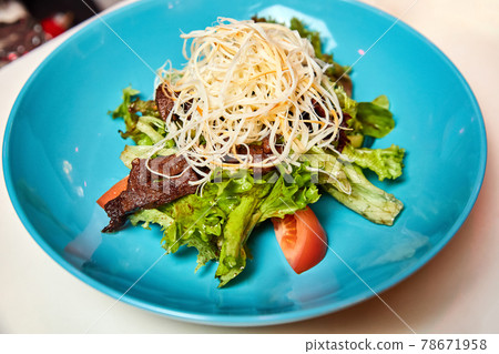 Warm salad with beef and smoked cheese. Close-up, selective focus. 78671958