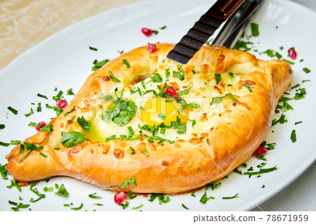 Ajarian traditional flatbread khachapuri or hachapuri with cheese, egg and butter on a plate 78671959