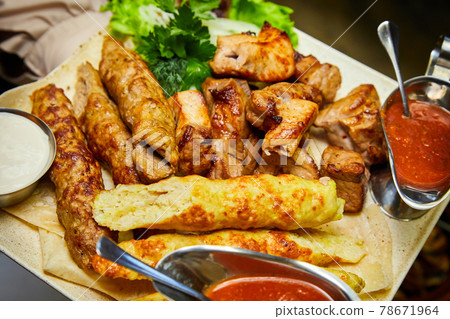 Baked kebabs and sausages. Close-up, selective focus 78671964