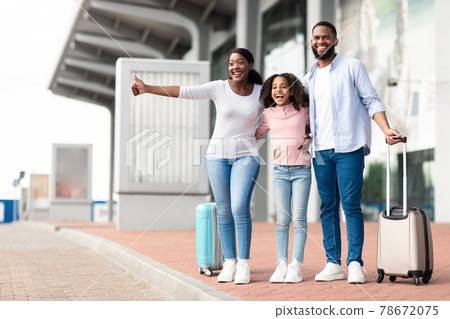Happy black family traveling with kid, catching taxi at airport 78672075