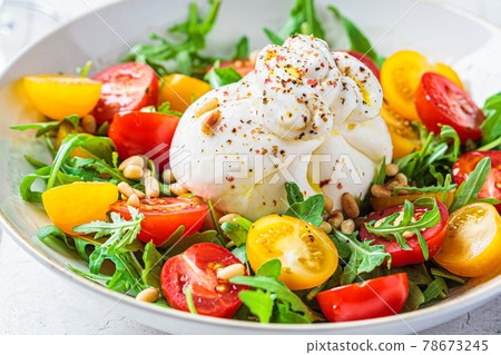 Burrata cheese salad with arugula and tomatoes. Italian cuisine concept. 78673245