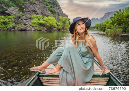 Woman tourist in Trang An Scenic Landscape Complex in Ninh Binh Province, Vietnam A UNESCO World Heritage Site. Resumption of tourism in Vietnam after quarantine Coronovirus COVID 19 Woman tourist in Trang An Scenic Landscape Complex in Ninh Binh Province, Vietnam A UNESCO World Heritage Site. Resumption of tourism in Vietnam after quarantine Coronovirus COVID 19 78676390